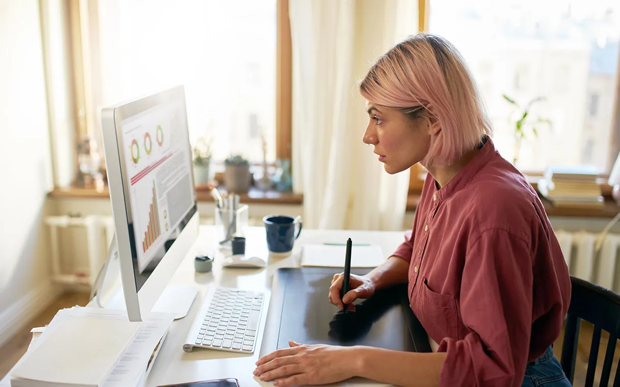 Persona che guarda un computer fisso alla scrivania